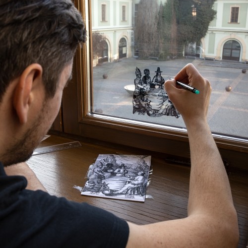 Jaro Varga draws the history of the Jesuits on the windows of the Zbrojnice library